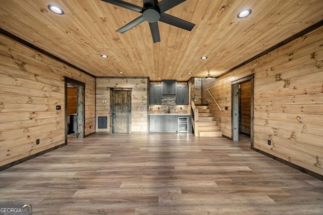 unfurnished living room featuring wooden walls, dark hardwood / wood-style floors, and wooden ceiling