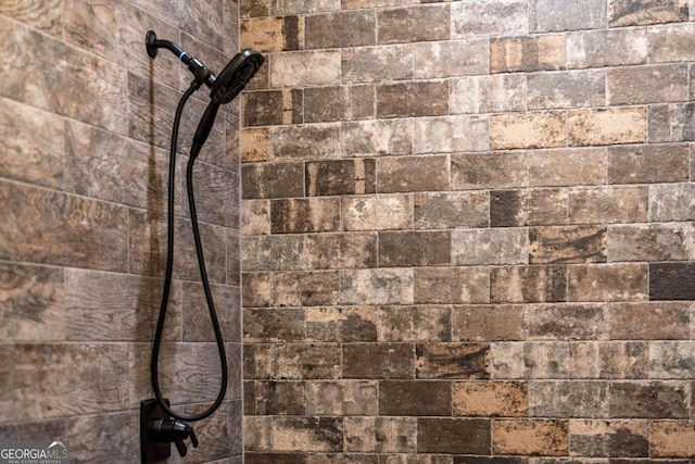 interior details with a tile shower