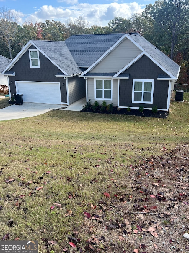 view of front of home featuring a front lawn, a garage, and cooling unit