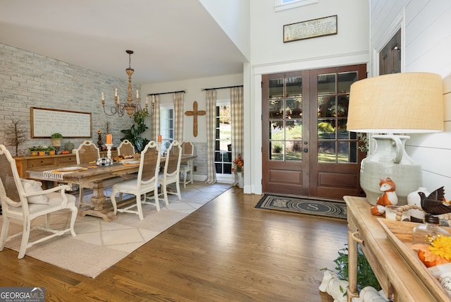 dining area with a chandelier, french doors, and hardwood / wood-style floors