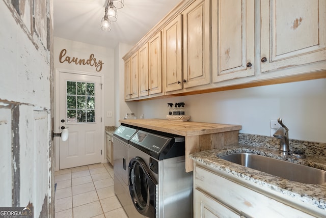 laundry area with washer and dryer, cabinets, light tile patterned floors, and sink