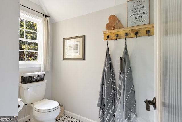 bathroom with tile patterned floors, vaulted ceiling, and toilet