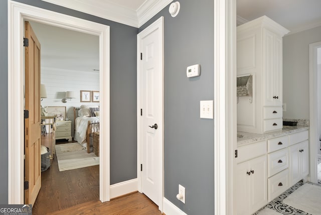 corridor featuring light hardwood / wood-style floors and crown molding