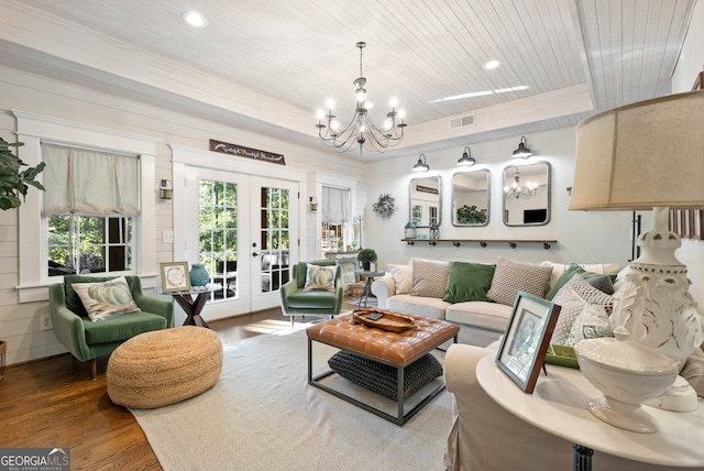 living room featuring french doors, an inviting chandelier, a healthy amount of sunlight, and hardwood / wood-style flooring