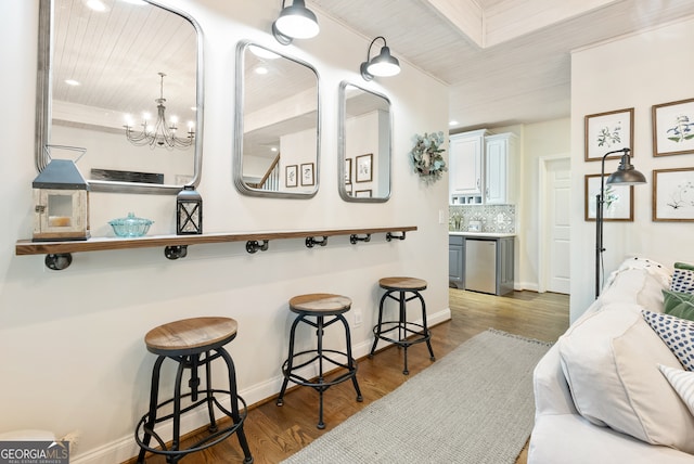 interior space with hardwood / wood-style flooring, tasteful backsplash, and an inviting chandelier