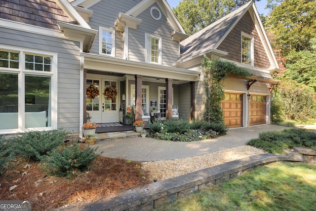 exterior space featuring a porch, a garage, and french doors