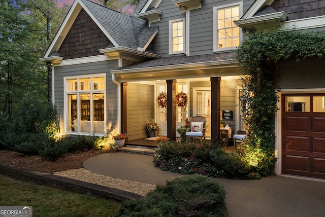 doorway to property featuring covered porch and a garage