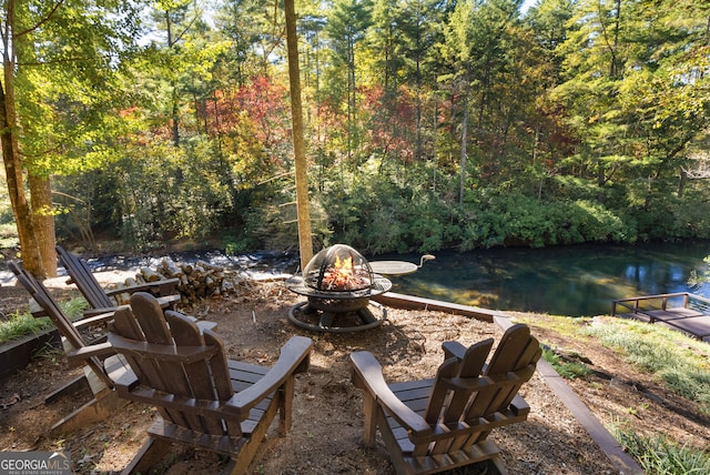 view of patio featuring a water view and a fire pit