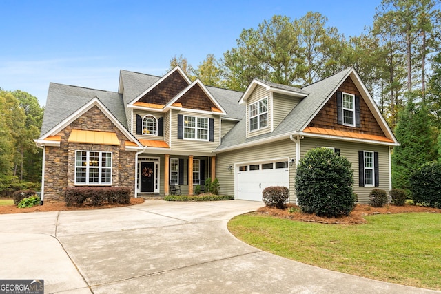 craftsman house with a front yard and a garage