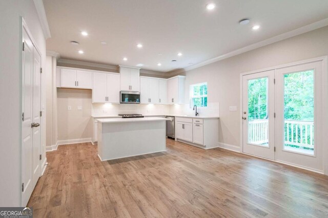 134 Henley St W Unit 09, Canton, GA 30114 - kitchen with appliances with stainless steel finishes, a sink, decorative backsplash, light countertops, and a center island
