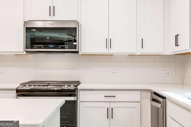 134 Henley St W Unit 09, Canton, GA 30114 - kitchen featuring appliances with stainless steel finishes, white cabinets, and decorative backsplash