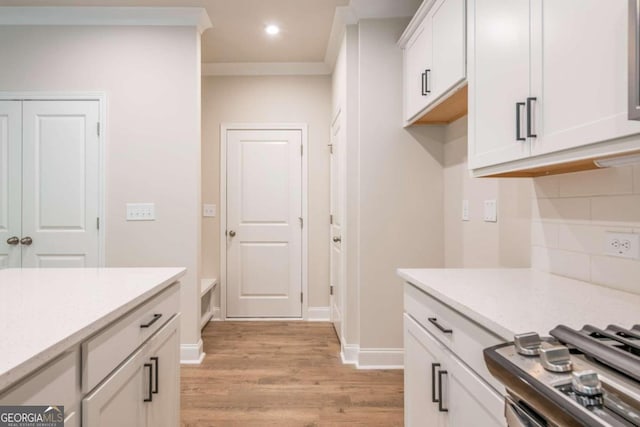 134 Henley St W Unit 09, Canton, GA 30114 - kitchen featuring light wood-style flooring, backsplash, white cabinetry, stove, and recessed lighting