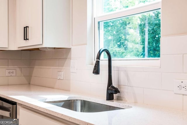 134 Henley St W Unit 09, Canton, GA 30114 - kitchen featuring a sink, white cabinets, light stone countertops, and backsplash