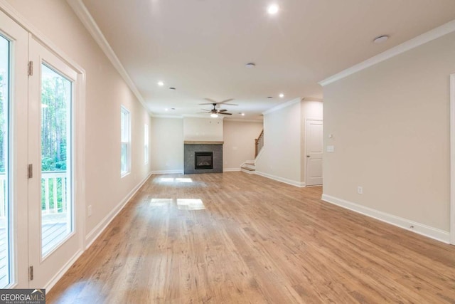 134 Henley St W Unit 09, Canton, GA 30114 - unfurnished living room with ornamental molding, a tile fireplace, baseboards, light wood-type flooring, and stairs