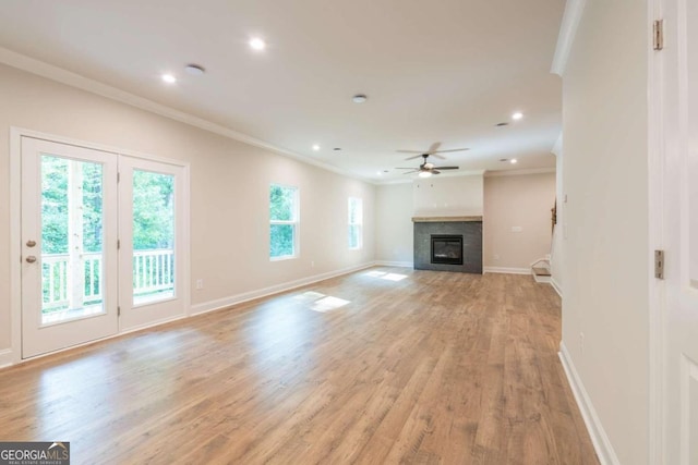 134 Henley St W Unit 09, Canton, GA 30114 - unfurnished living room featuring ornamental molding, a glass covered fireplace, a ceiling fan, light wood-type flooring, and baseboards