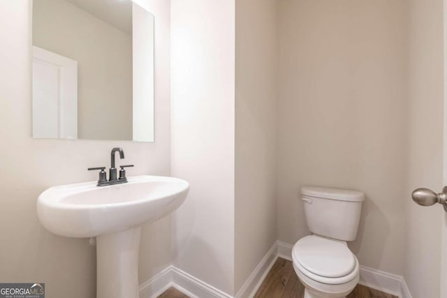 134 Henley St W Unit 09, Canton, GA 30114 - half bathroom featuring toilet, baseboards, and wood finished floors