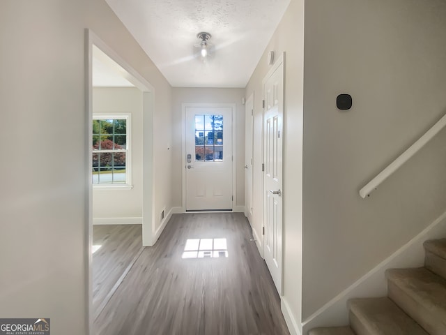 entryway with a textured ceiling and light hardwood / wood-style floors