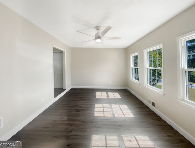 spare room featuring ceiling fan, plenty of natural light, and dark hardwood / wood-style flooring