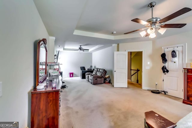 interior space with light colored carpet, a tray ceiling, and ceiling fan