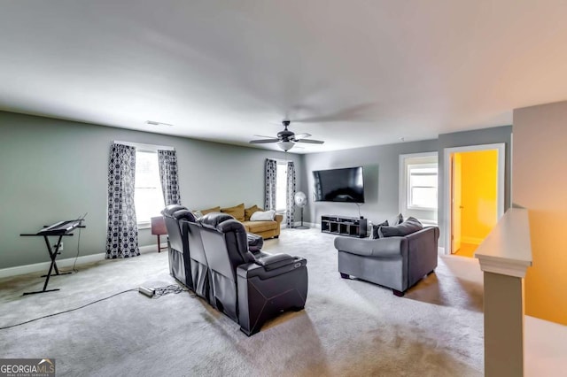 living room featuring ceiling fan, light carpet, and a wealth of natural light