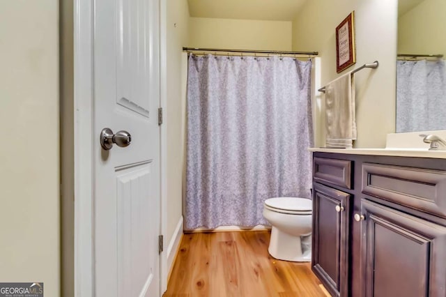 bathroom featuring vanity, toilet, hardwood / wood-style flooring, and a shower with shower curtain