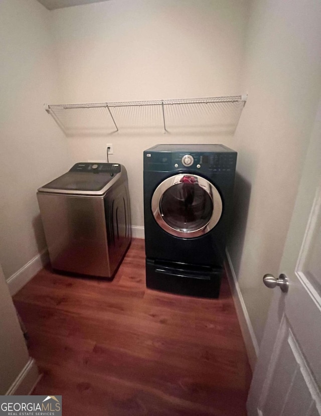 laundry area featuring washer and dryer and dark hardwood / wood-style flooring