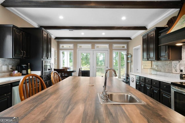 kitchen with beam ceiling, sink, appliances with stainless steel finishes, and wood counters