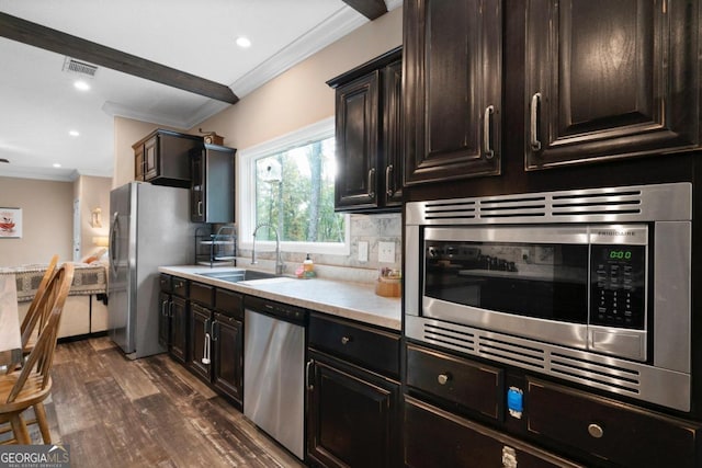 kitchen featuring decorative backsplash, dark hardwood / wood-style floors, crown molding, sink, and appliances with stainless steel finishes