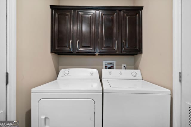 laundry room with washer and clothes dryer and cabinets