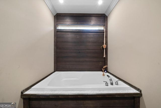 bathroom with a bath and crown molding