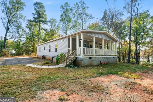 manufactured / mobile home with covered porch and a front yard