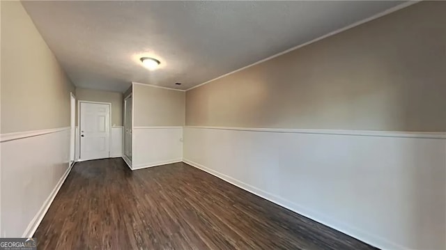 spare room featuring crown molding and dark hardwood / wood-style floors