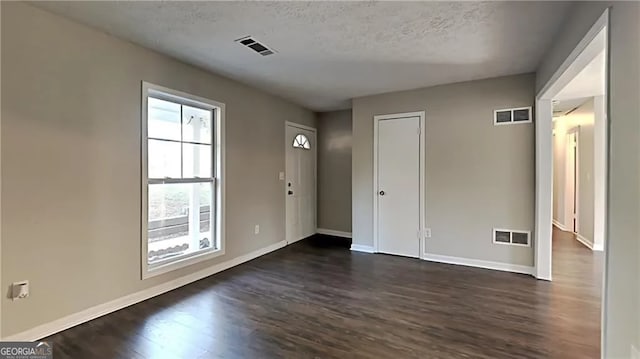 interior space featuring a textured ceiling and dark hardwood / wood-style floors