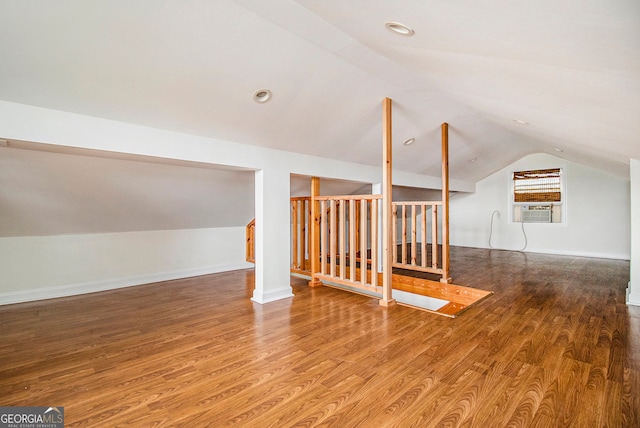 additional living space with lofted ceiling, wood-type flooring, and cooling unit