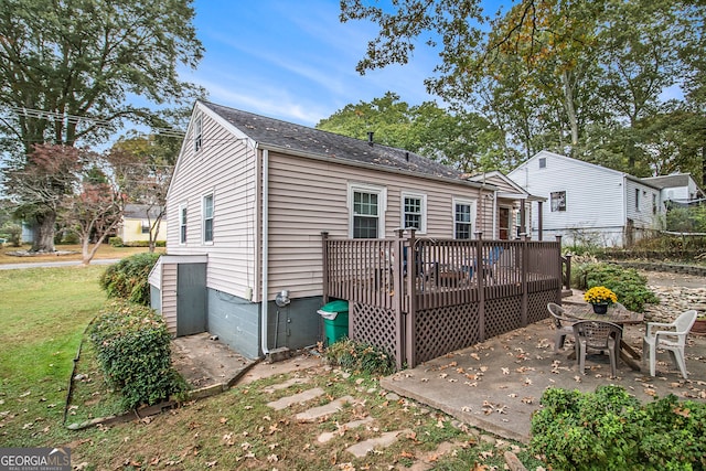 rear view of house with a lawn, a patio area, and a deck