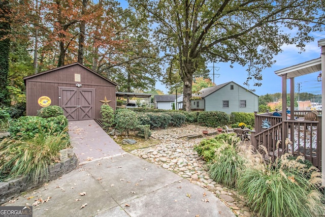 view of yard featuring a storage unit and a wooden deck