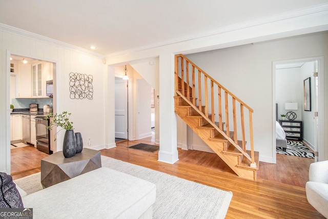 living room featuring ornamental molding and light hardwood / wood-style flooring