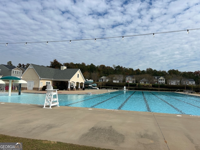 view of swimming pool with pool water feature and a patio