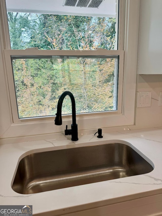 interior details with light stone countertops and sink