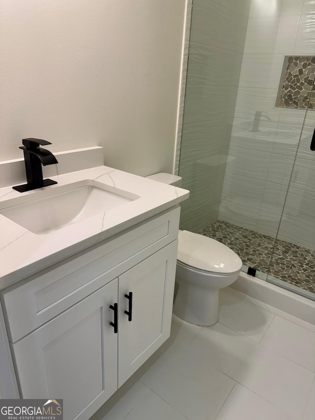 bathroom featuring vanity, toilet, and an enclosed shower