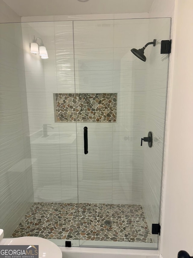 bathroom with toilet and a shower stall