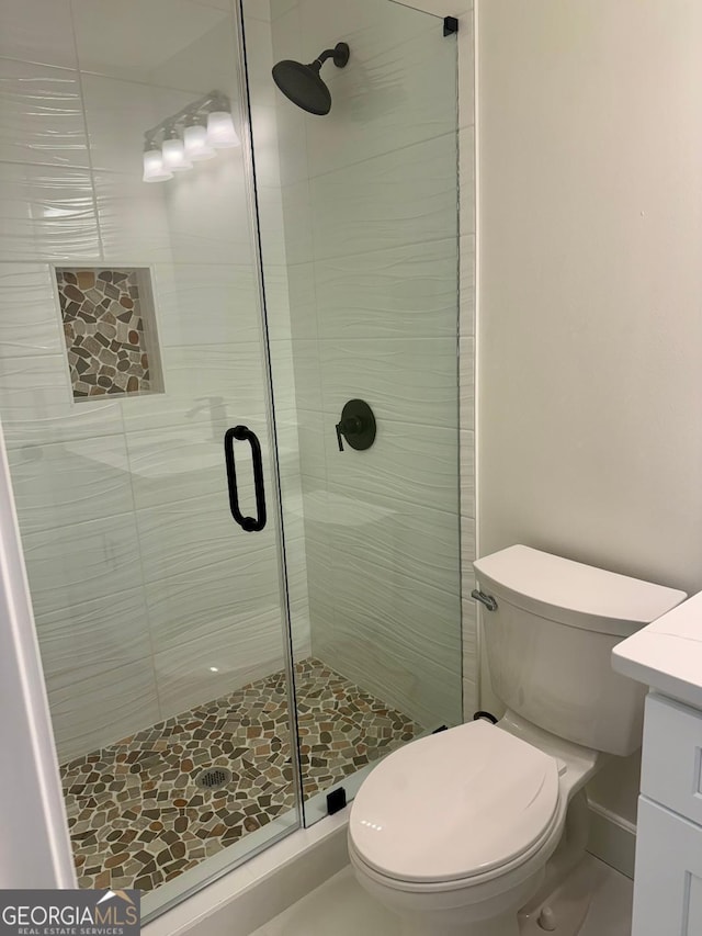 bathroom featuring vanity, toilet, and walk in shower