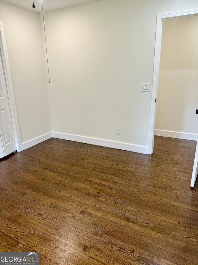 spare room with dark wood-type flooring