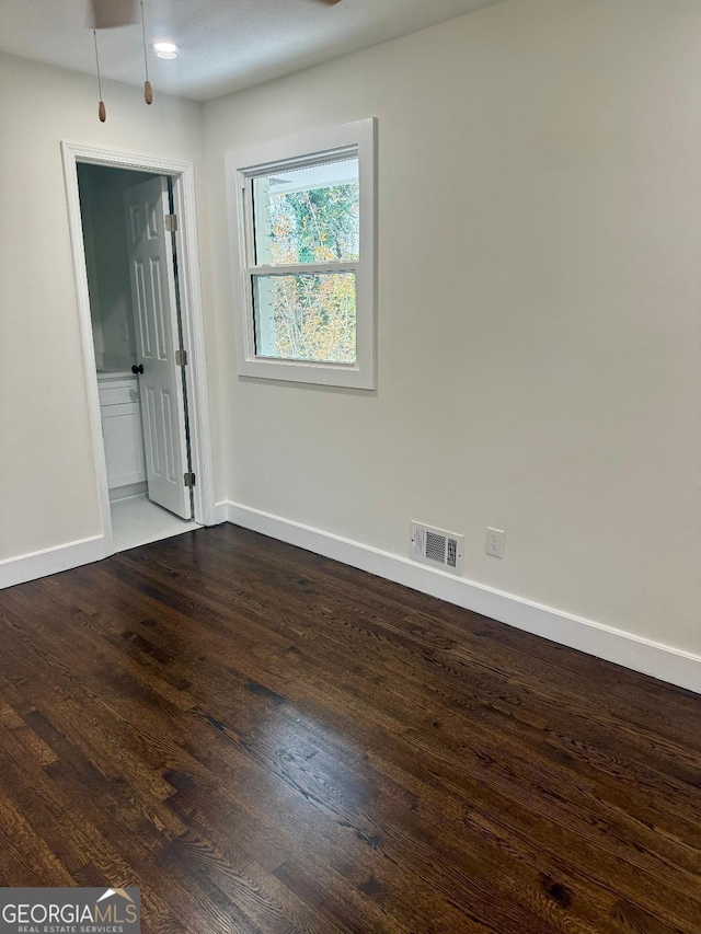 unfurnished room with dark hardwood / wood-style floors and ceiling fan