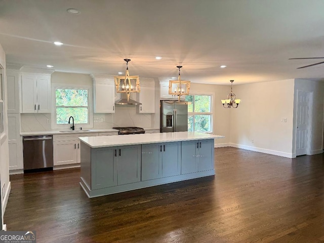 kitchen featuring dark wood-type flooring, sink, a center island, white cabinets, and appliances with stainless steel finishes