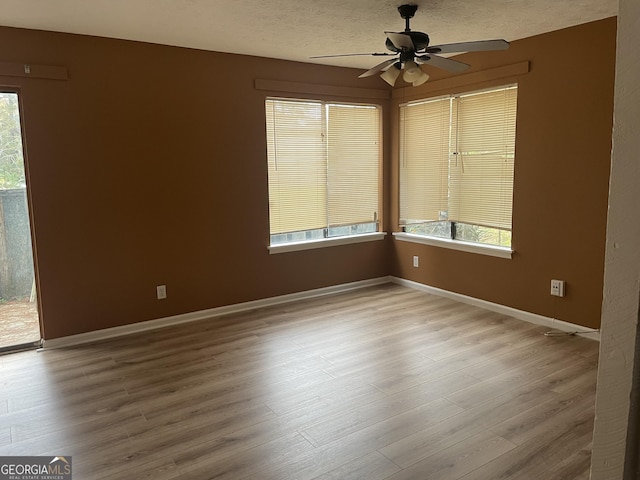 8596 Creekwood Way, Jonesboro, GA 30238 - empty room with wood finished floors, a ceiling fan, a textured ceiling, and baseboards