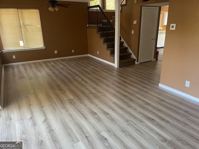 8596 Creekwood Way, Jonesboro, GA 30238 - unfurnished living room with stairway, ceiling fan, baseboards, and wood finished floors