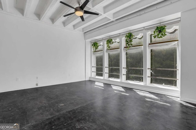 empty room featuring ceiling fan, beamed ceiling, and concrete floors