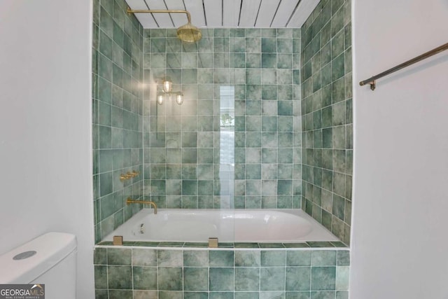 bathroom featuring toilet and tiled shower / bath combo