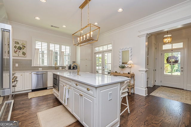 kitchen featuring a kitchen island, stainless steel appliances, dark hardwood / wood-style flooring, white cabinets, and tasteful backsplash